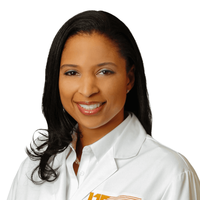 Smiling woman with long black hair wearing a white lab coat, posing against a white background.