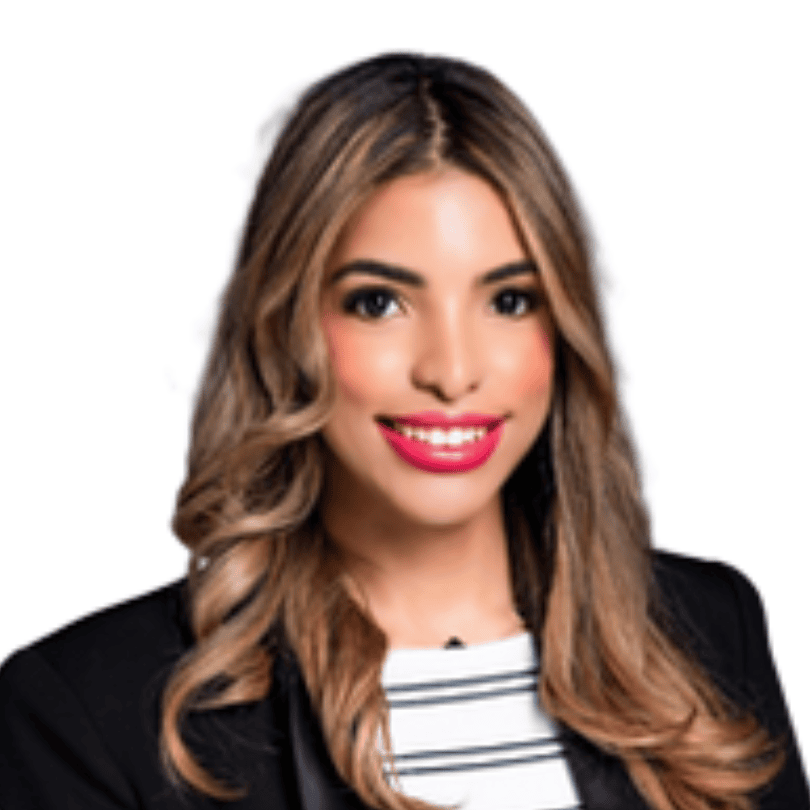 A woman with long wavy hair, wearing a black blazer over a white top, smiles at the camera against a white background.