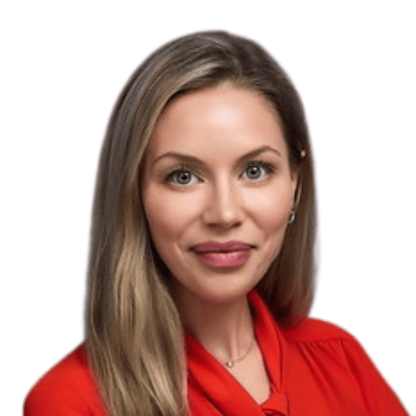 Smiling woman with long blonde hair, wearing a red blouse, in front of a plain white background.